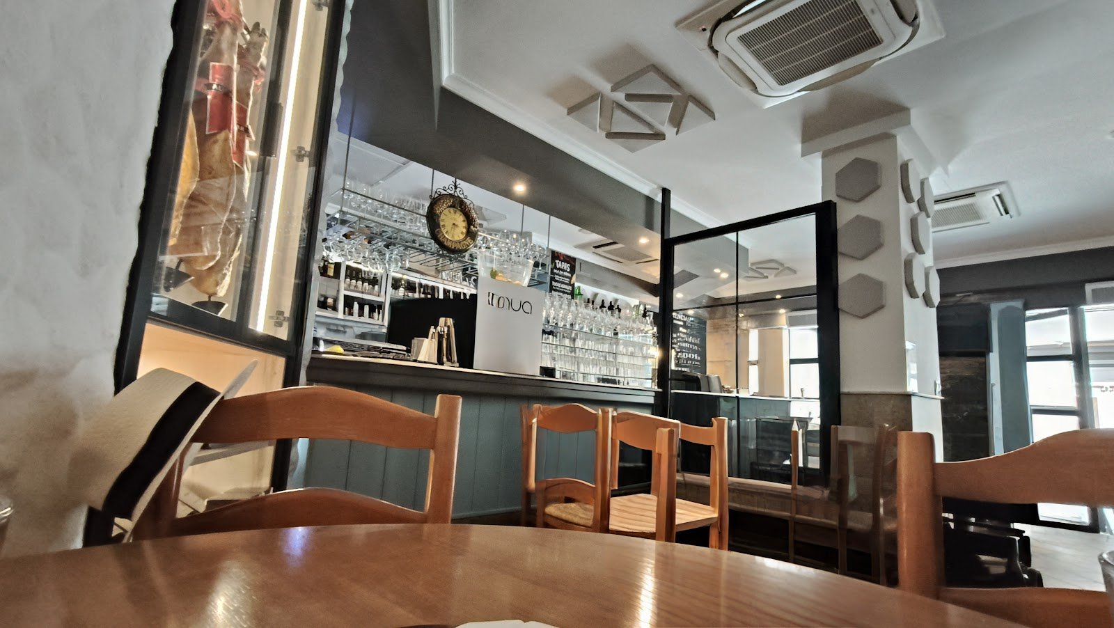 Interior de Restaurante Las Tablas, barra de madera con botellas y ambiente cálido de restaurante tradicional andaluz